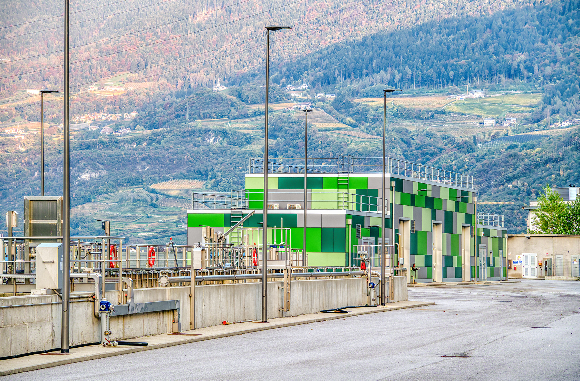 Impianto di depurazione Eco Center a Salorno, un edificio verde lime moderno immerso tra montagne e alberi